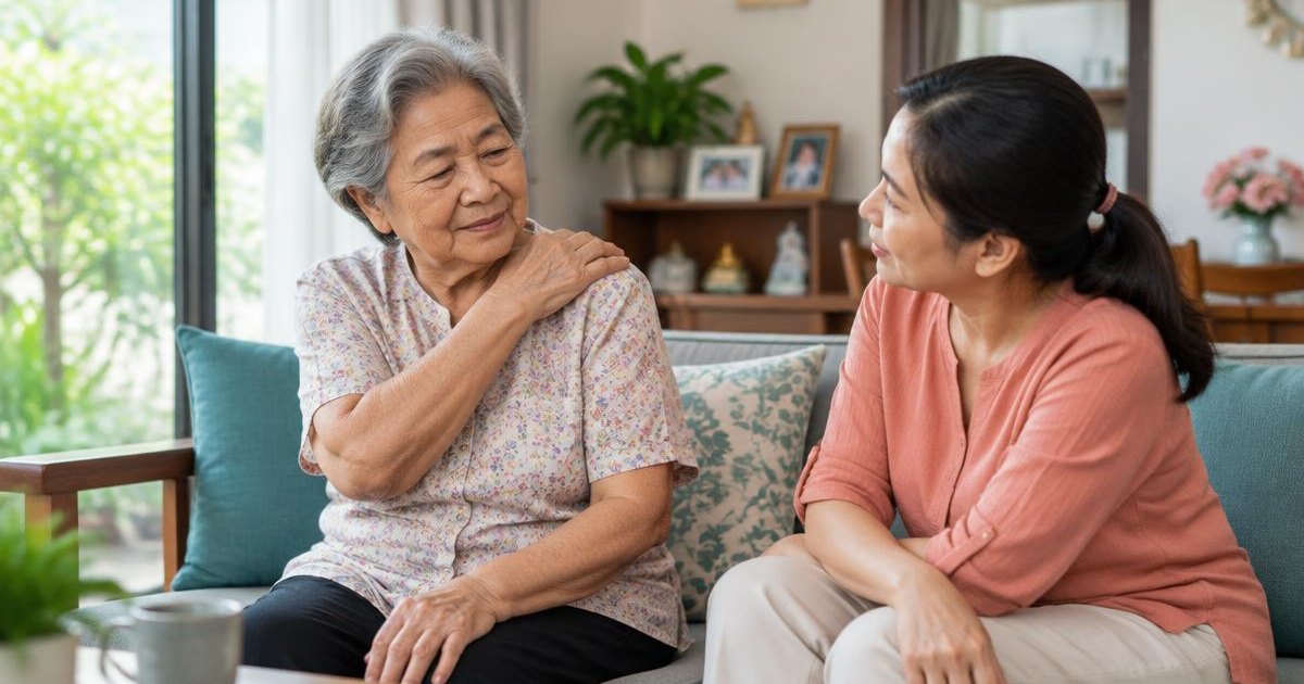 ลูกสาวนั่งคุยกับคุณแม่ผู้สูงอายุที่กำลังจับไหล่ข้างที่ปวด